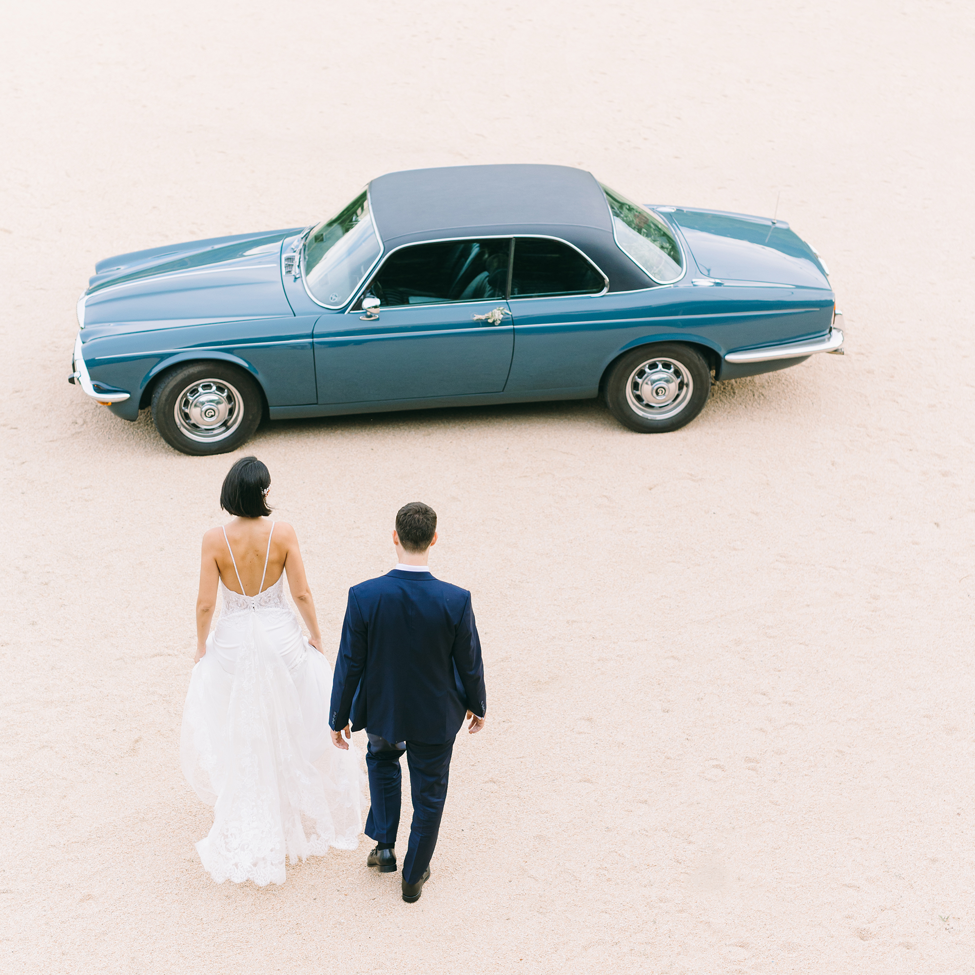 Stepping into Forever – Catalina & Miquel walk towards a timeless vintage car, surrounded by the charm of Masia Can Colomer near Barcelona. A destination wedding filled with love, history, and unforgettable moments