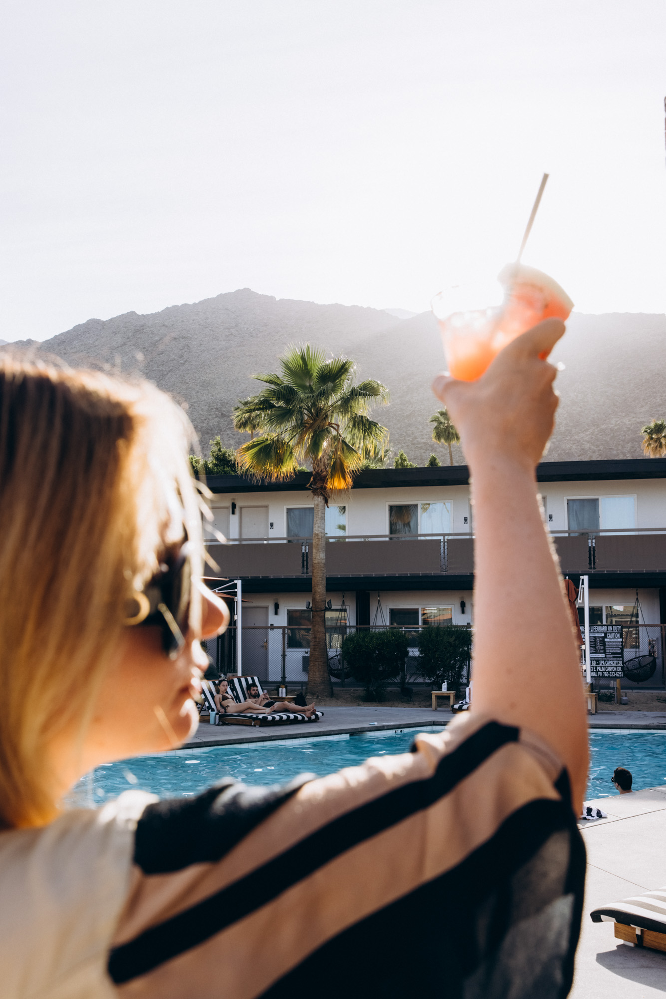 The V Palm Springs by sonder, beautiful girl relaxing in the pool with coctail