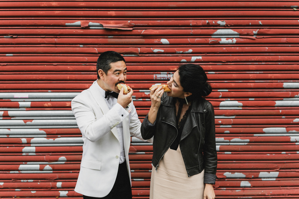 Bride and groom eating hot dogs on their wedding day, Brooklyn NY