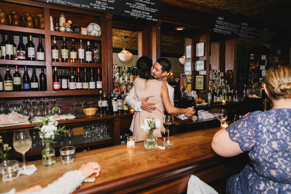 Bride and groom hugging at a bar during their reception at Sweetwater restaurant, Brooklyn NY