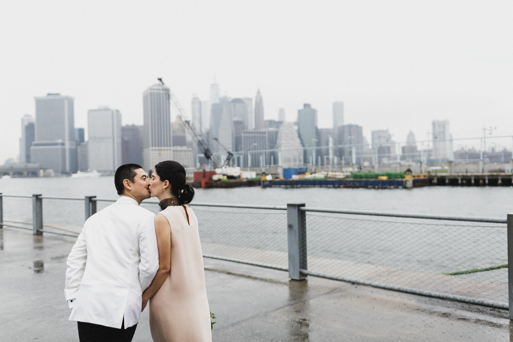 Bride and groom sharing a kiss as they walk on a pier in Brooklyn NY