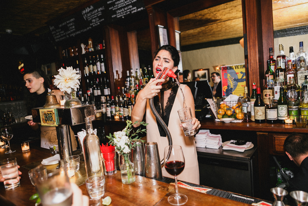 Bride pouring drinks for guests at a bar at Sweetwater restaurant Brooklyn NY