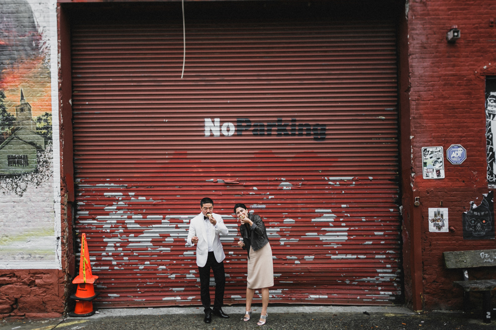 Bride and groom eating hot dogs on their wedding day, Brooklyn NY