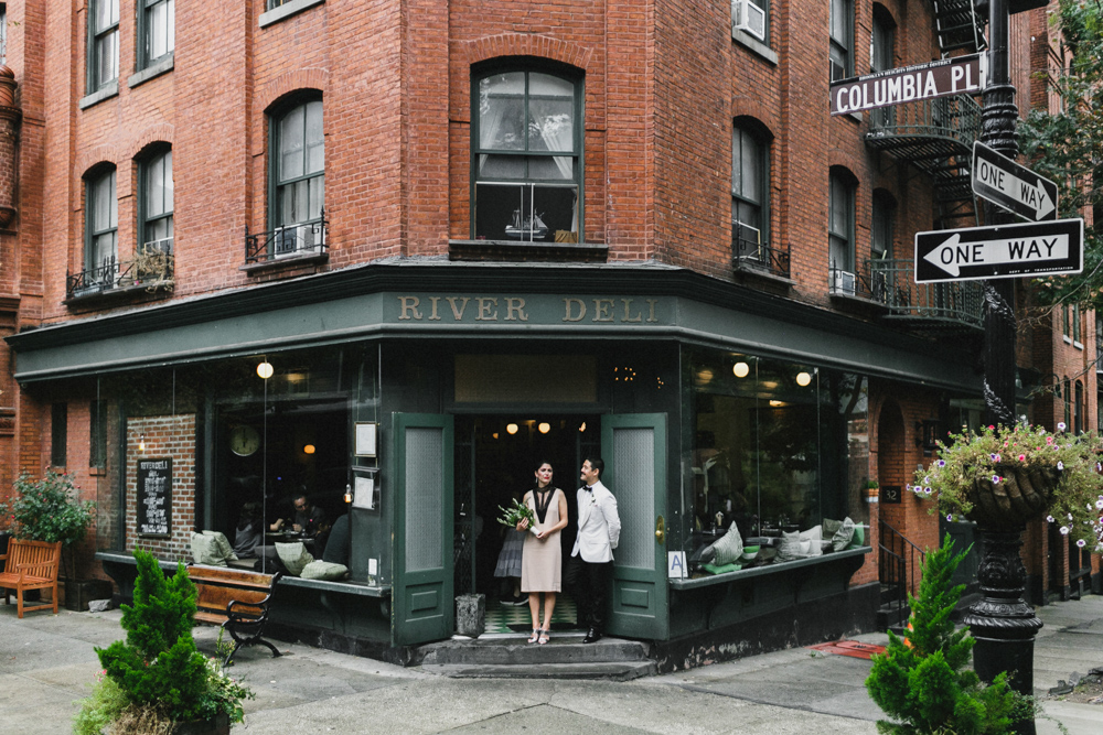 Excited bride and groom standing in front of a deli in Brooklyn Heights, Brooklyn NY