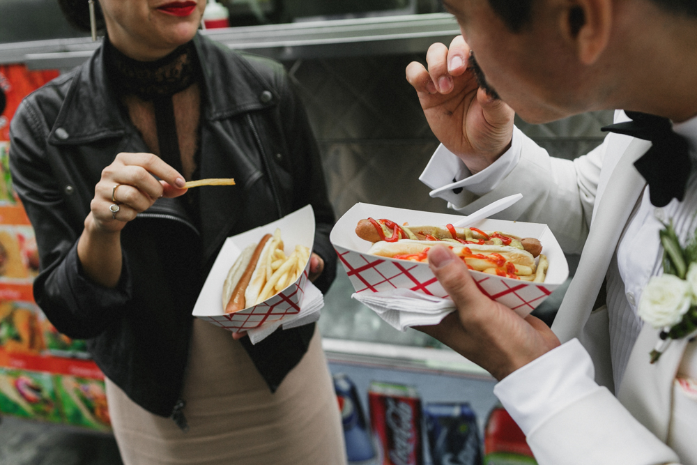 Bride and groom eating hot dogs on their wedding day, Brooklyn NY