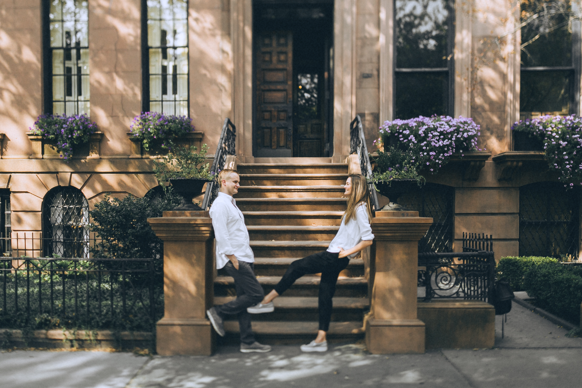 Couple enjoying the moment, wide angle shot, Browne stone building on the background, NYC portrait photo session, Brooklyn Promenade