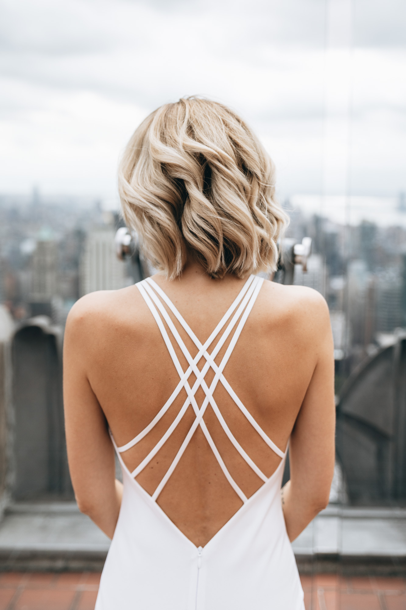 Close up of the bride standing at Top of the Rock on her wedding day, details of the dress from the back. Manhattan NYC