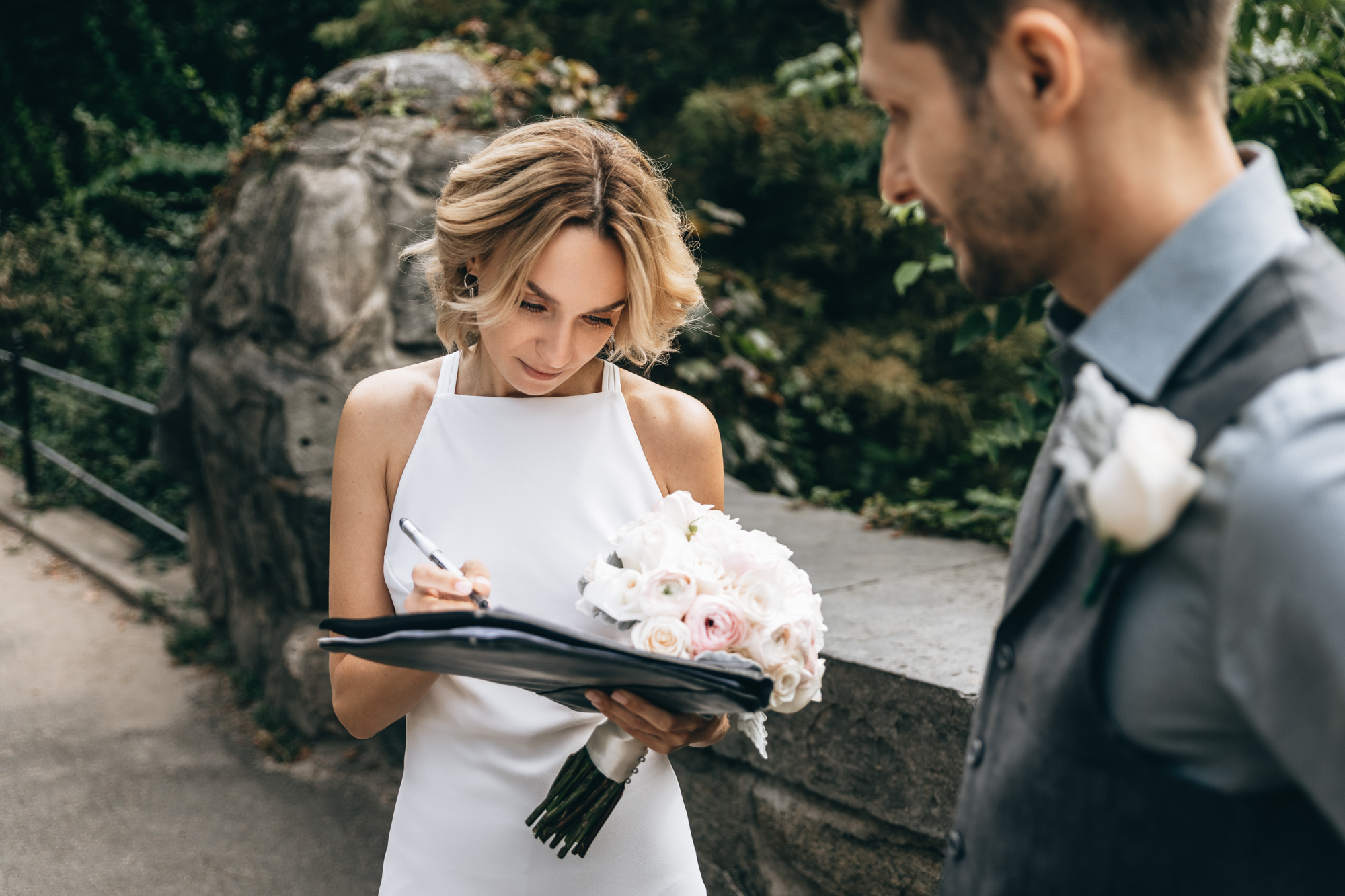 Bride signing the marriage license during an elopement ceremony in Central Park, Manhattan NY