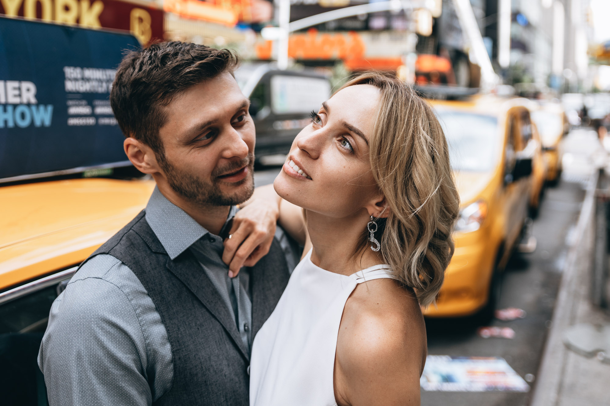 Bride and groom standing next to a yellow cab in Manhattan on their elopement day.