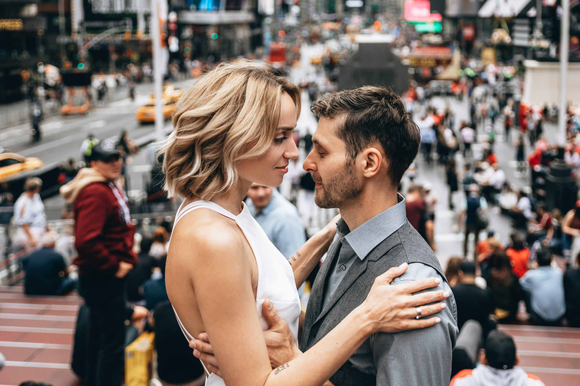 Bride and groom standing together in Time Square on their wedding day. Manhattan NYC