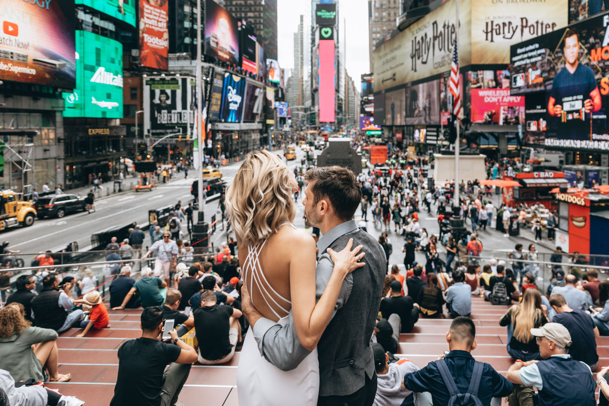 Bride and groom standing together in Time Square on their wedding day. Manhattan NYC