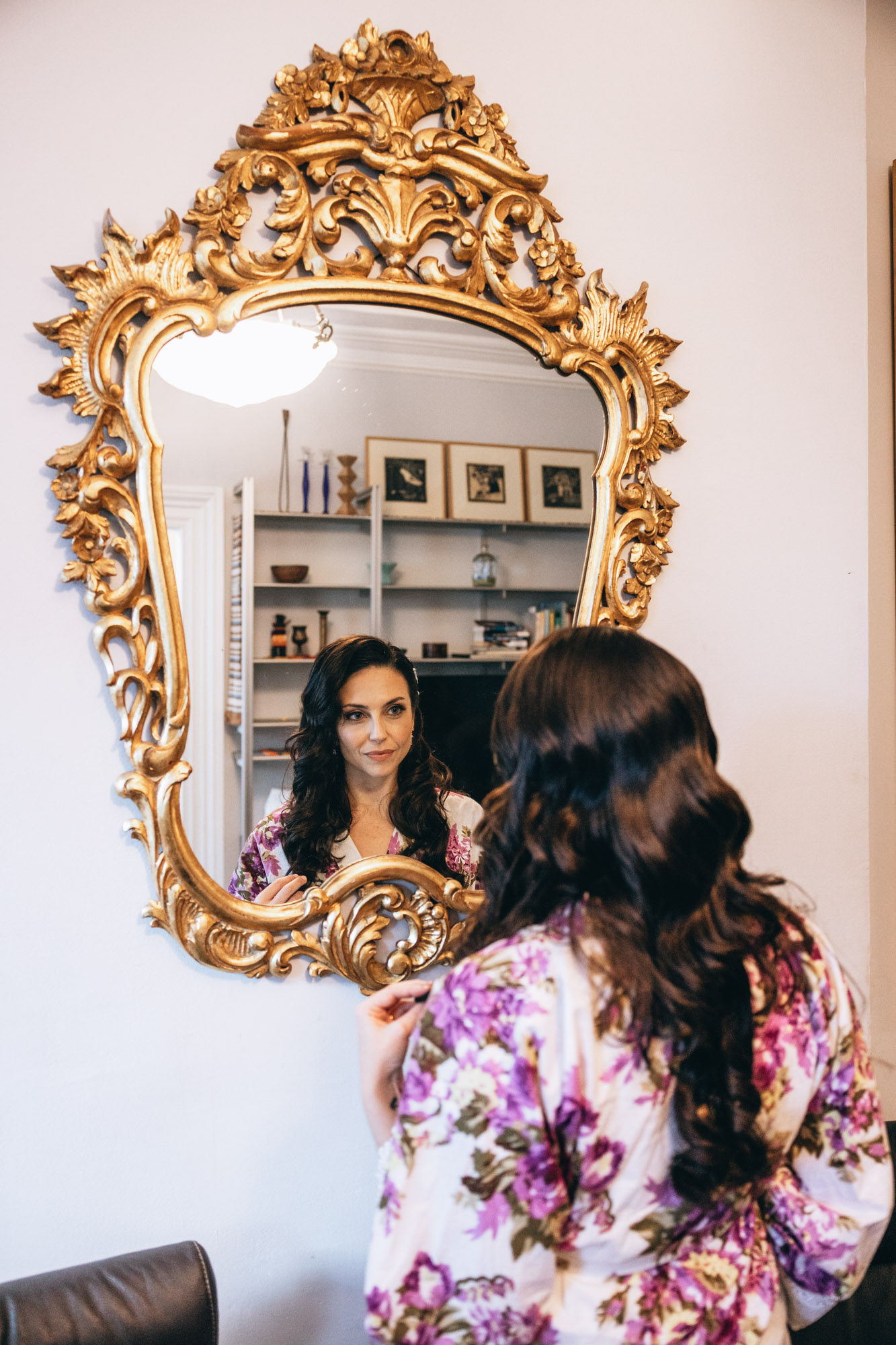 Stunning bride looking at an antique mirror on her wedding day. Brooklyn, NY