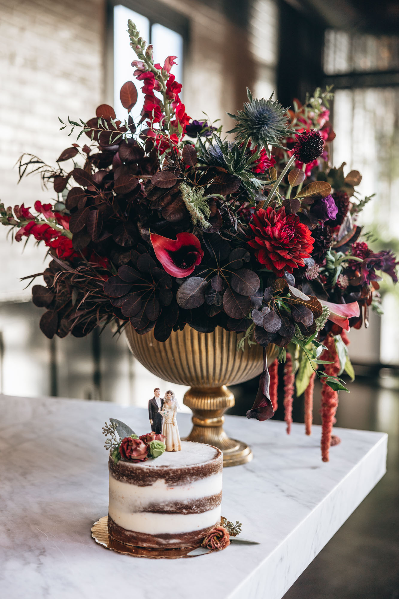 Stunning dark and moody floral centerpiece and wedding cake at 501 Union, Brooklyn NY