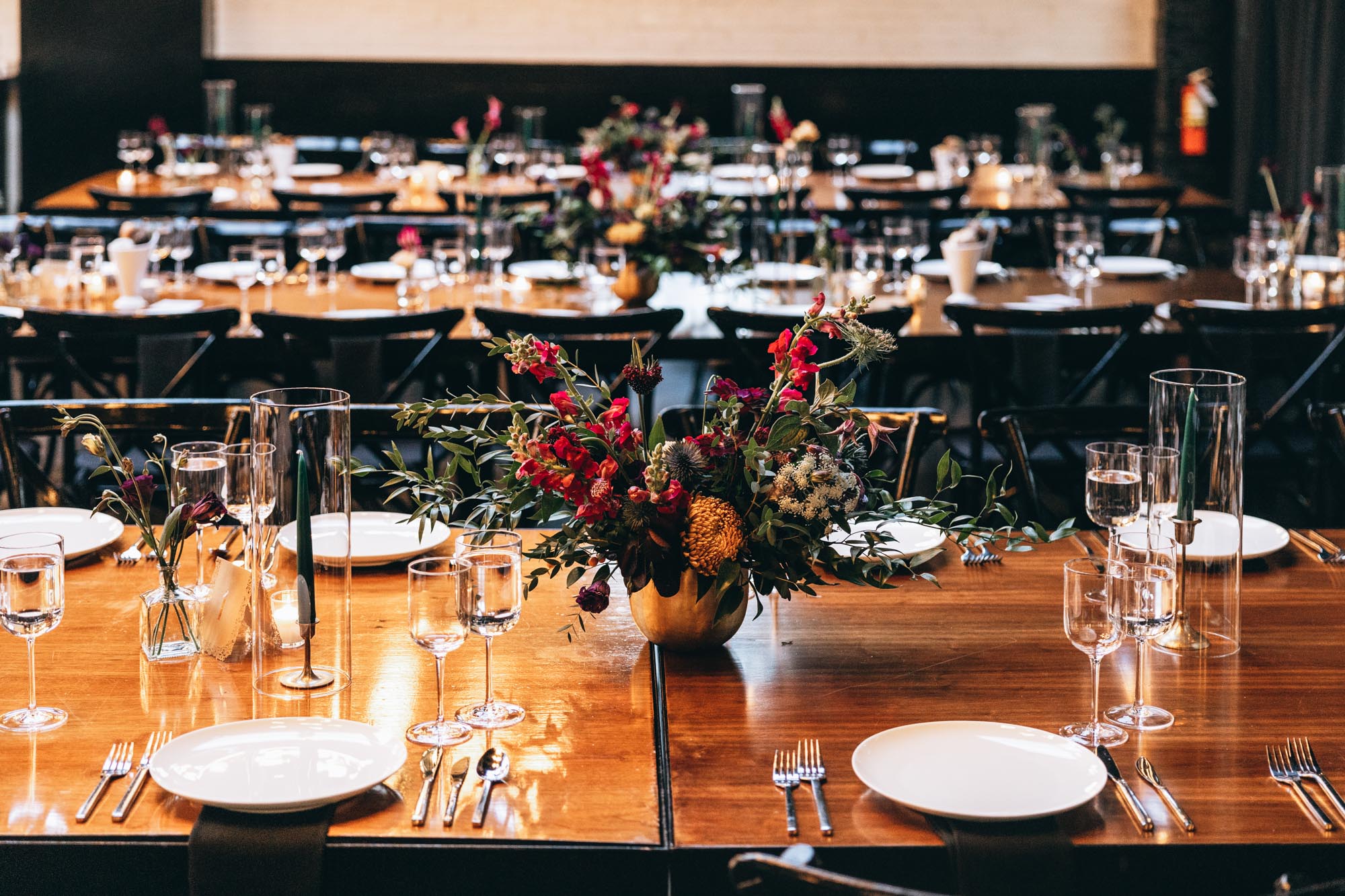 Dark and bold tables with floral centerpieces at a wedding in 501 Union, Brooklyn, NY