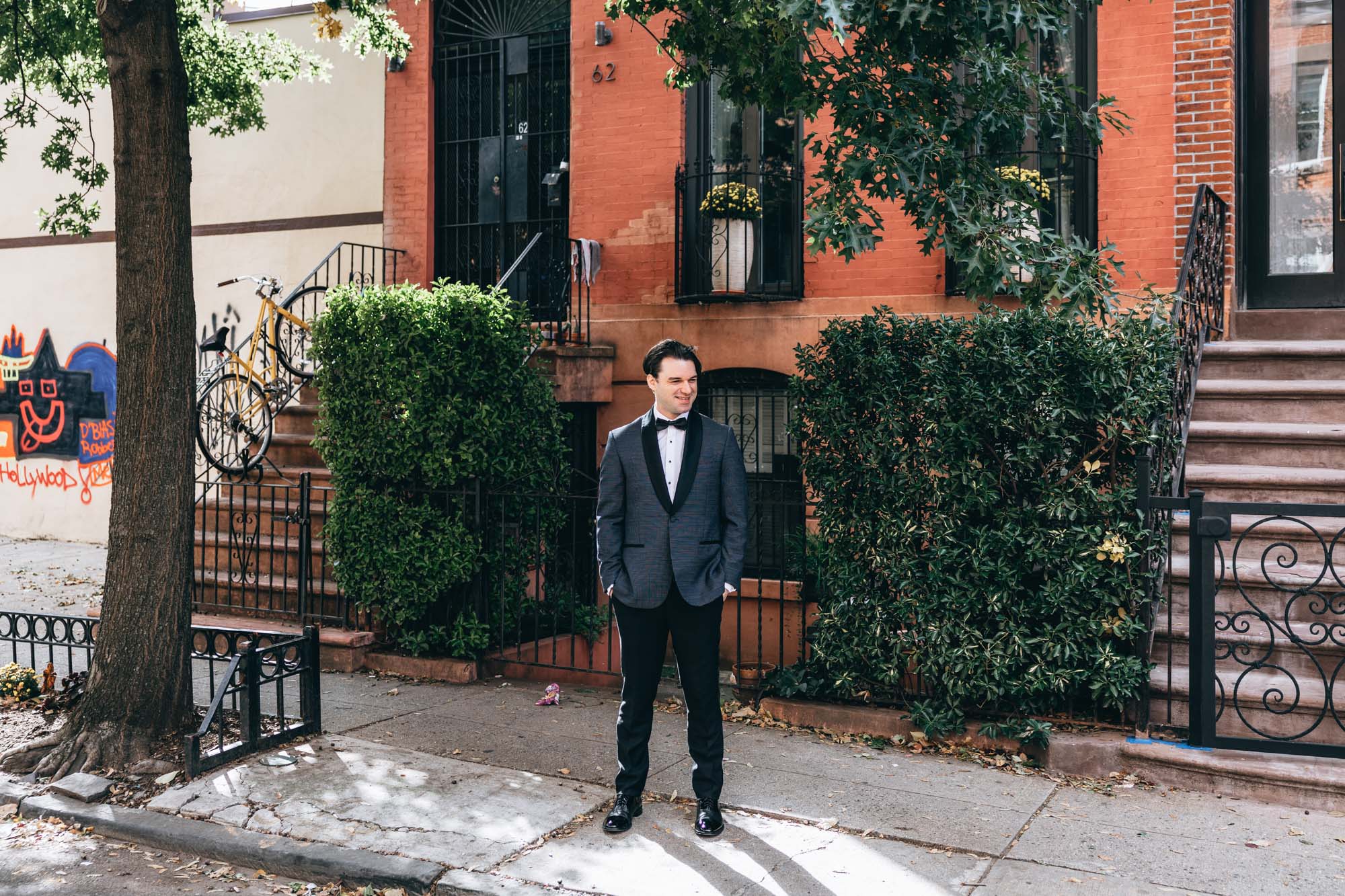 Groom standing in front of brownstones in Brooklyn, NY moments before the first look