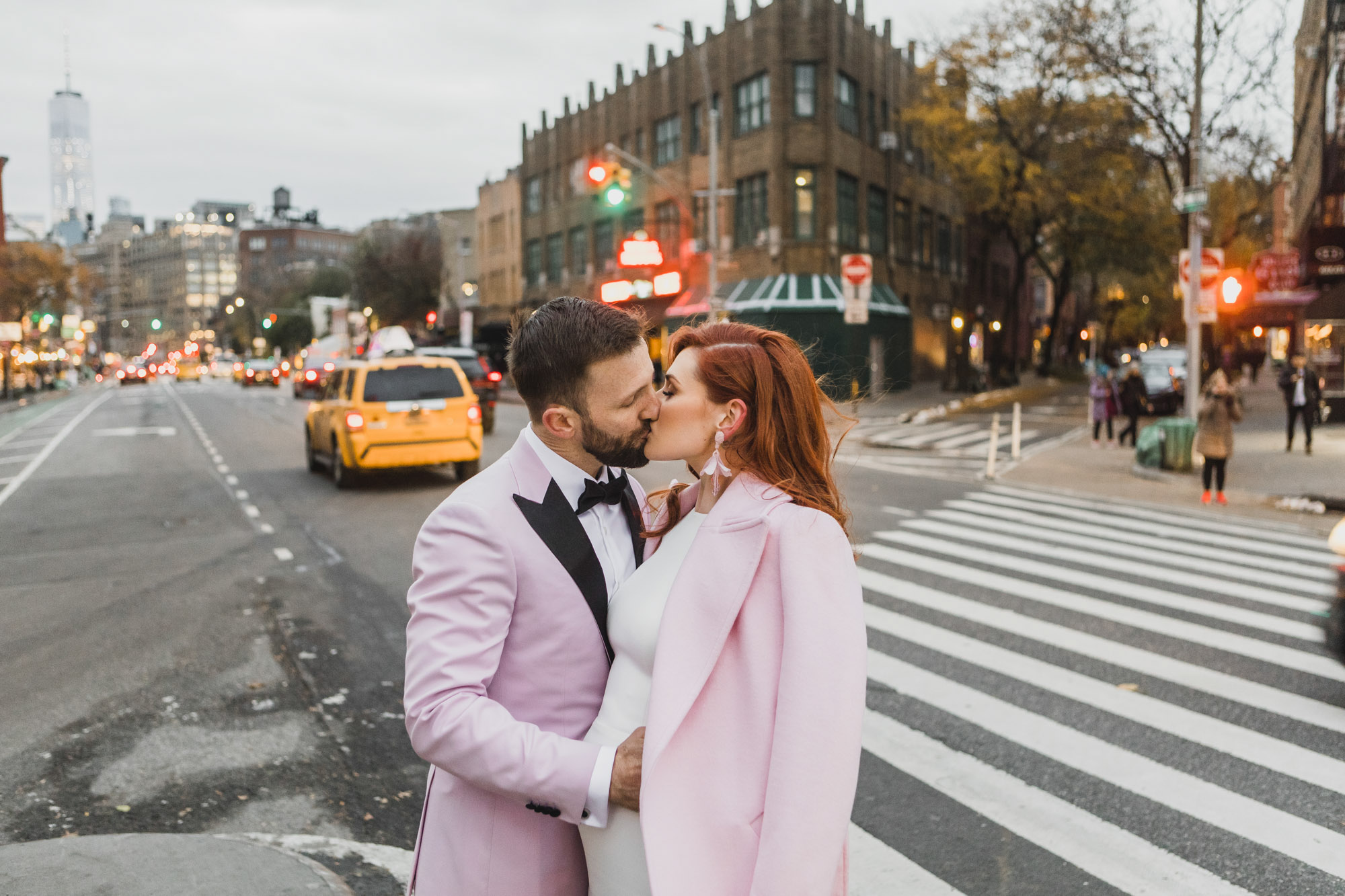 Aussie bride and groom in light pink outfits kissing in the street in West Village, Manhattan NY