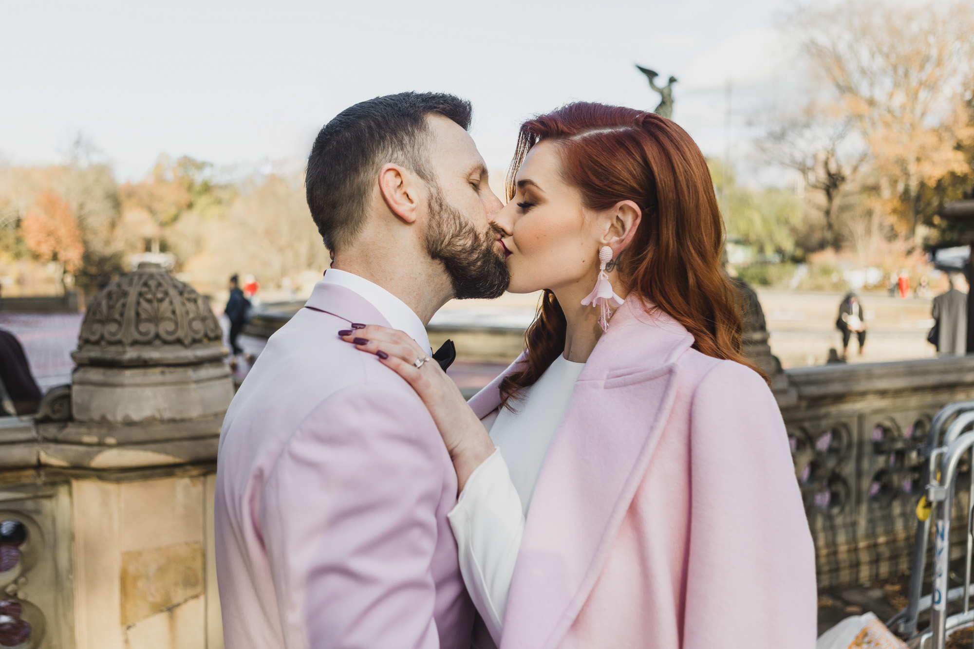 Aussie bride and groom in light pink outfits kissing during their elopement at Bethesda Fountain and Terrace, Central Park. Manhattan, NY