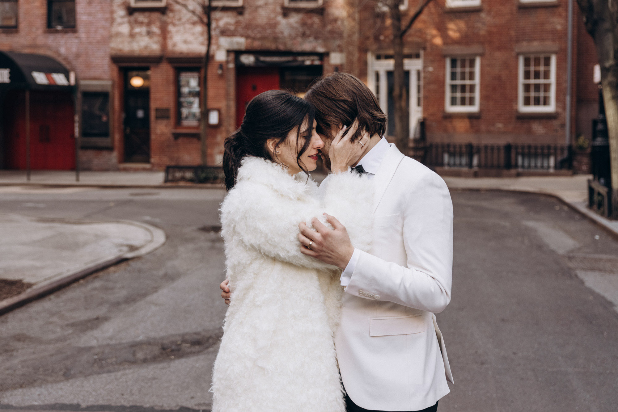 Stylish bride and groom walking in a fuzzy fur coat in the West Village. Manhattan NY