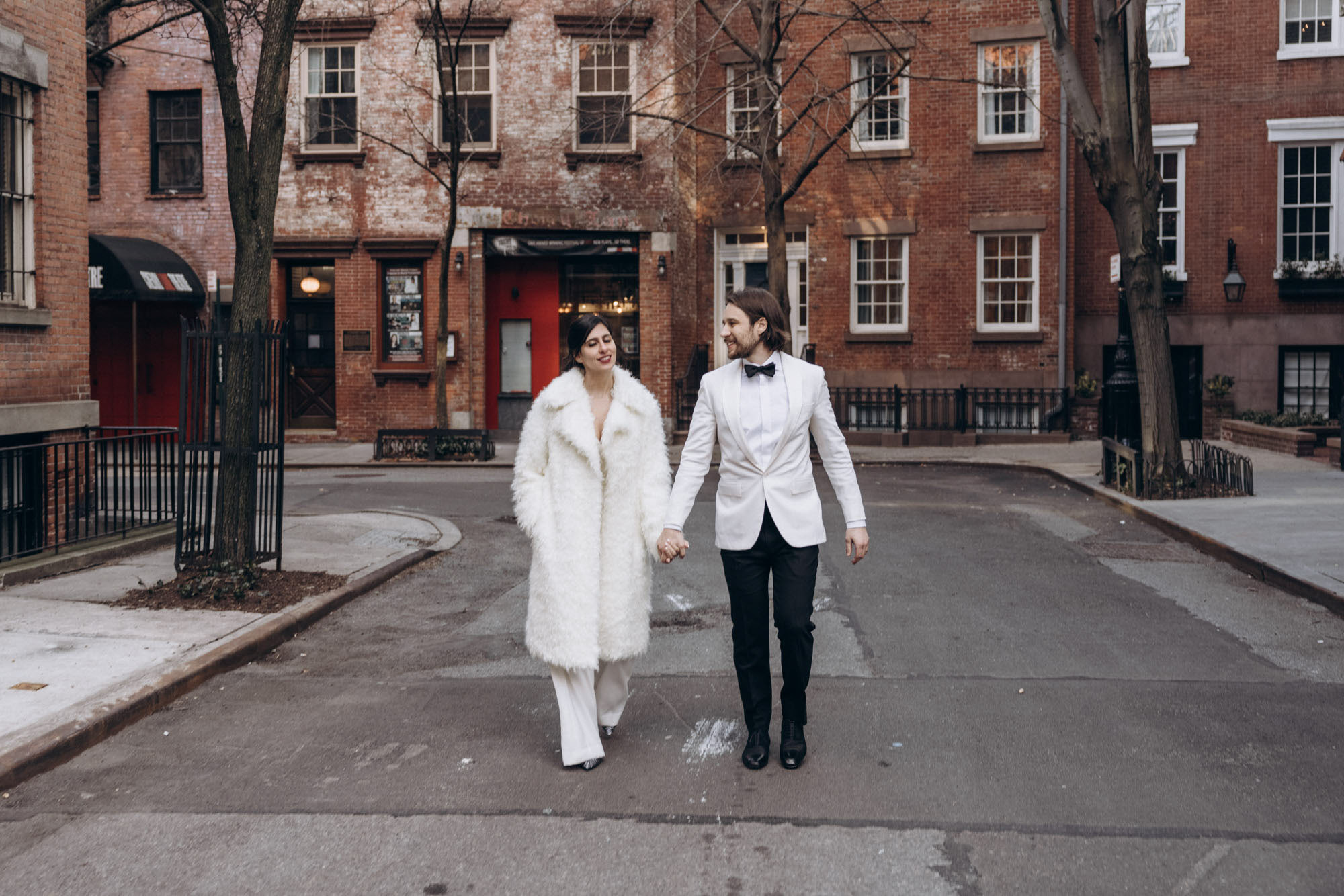 Stylish bride and groom walking in a fuzzy fur coat in the West Village. Manhattan NY
