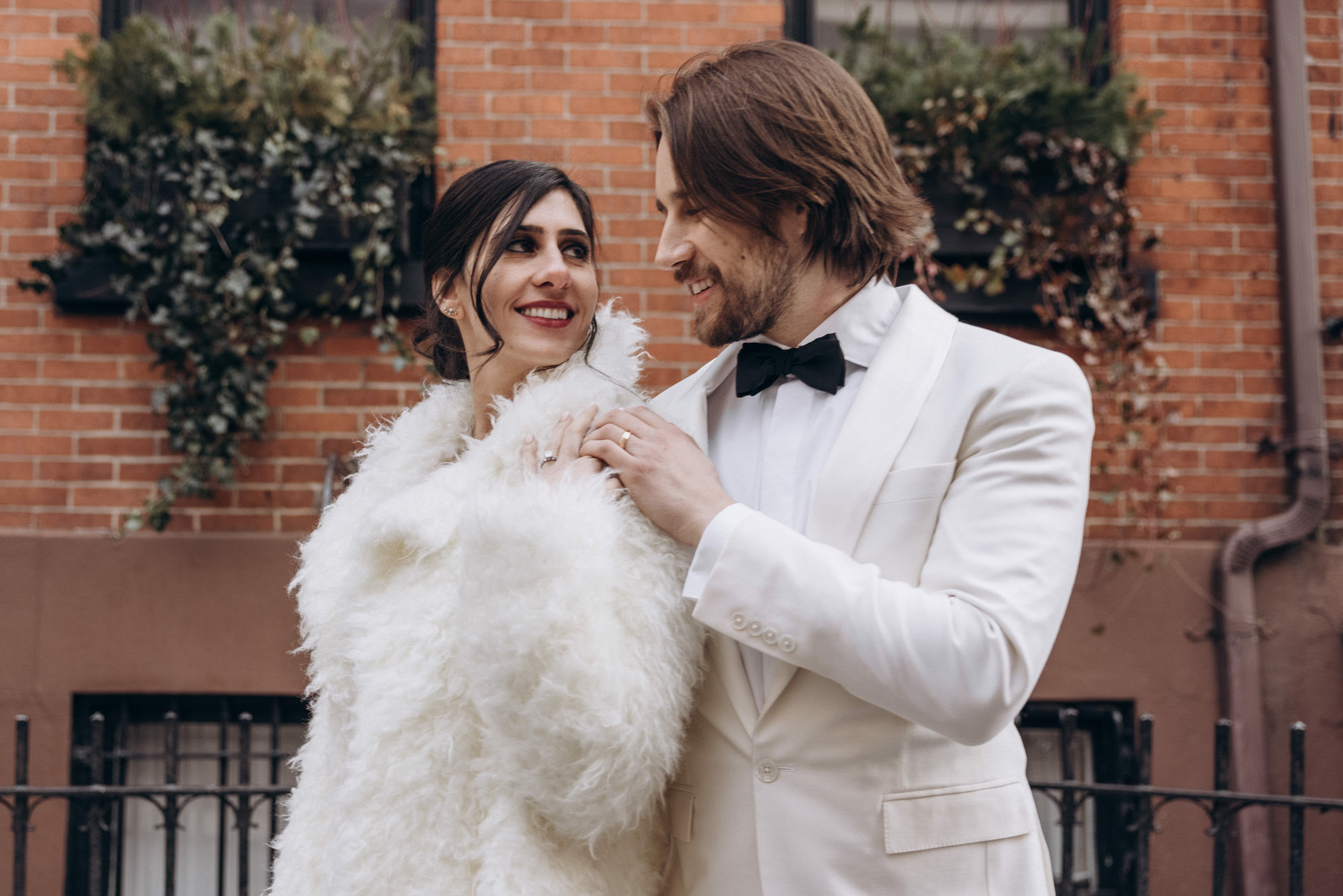 Stylish bride and groom walking in a fuzzy fur coat in the West Village. Manhattan NY
