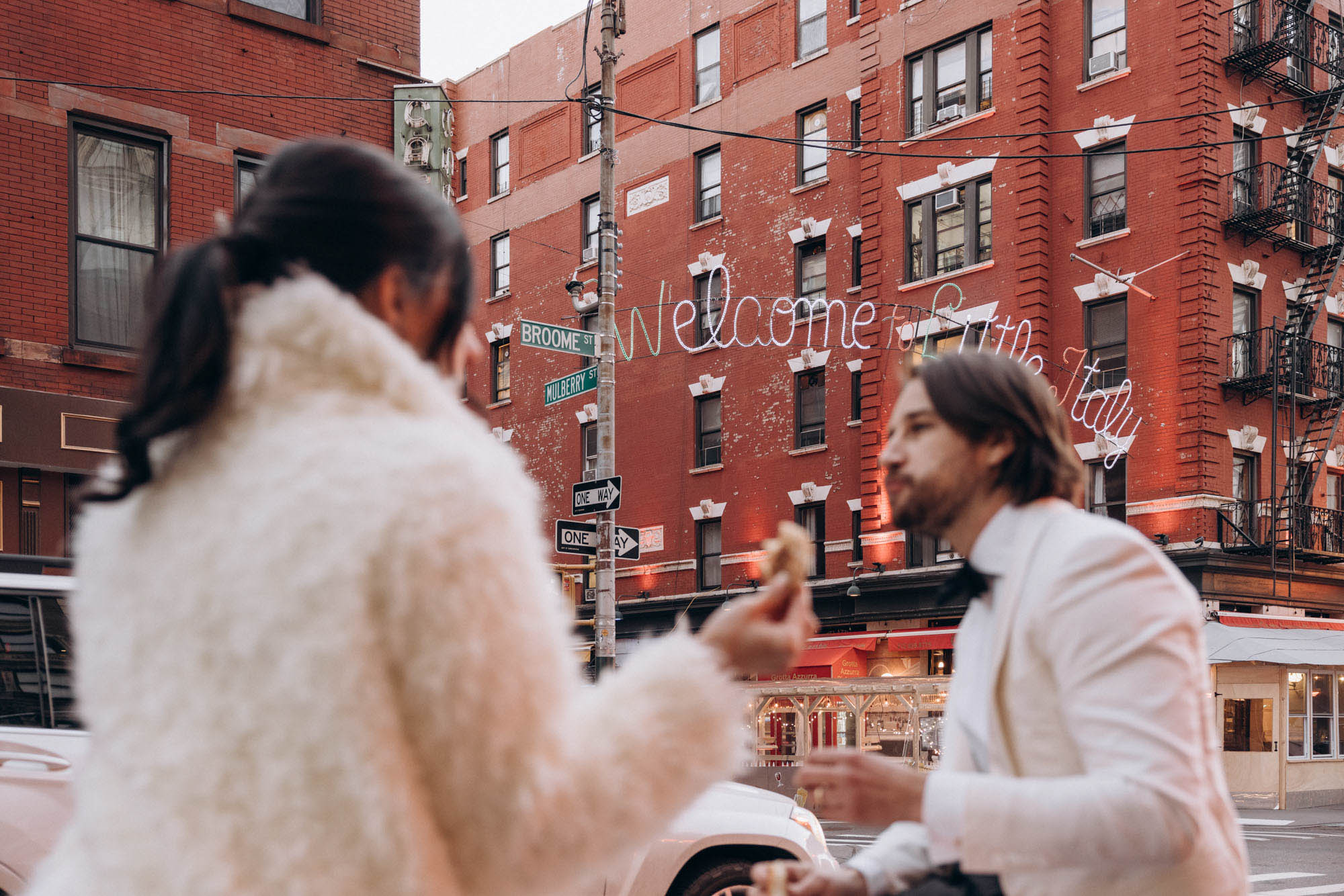Bride and groom eating pizza during their winter elopement in Little Italy, Manhattan NY