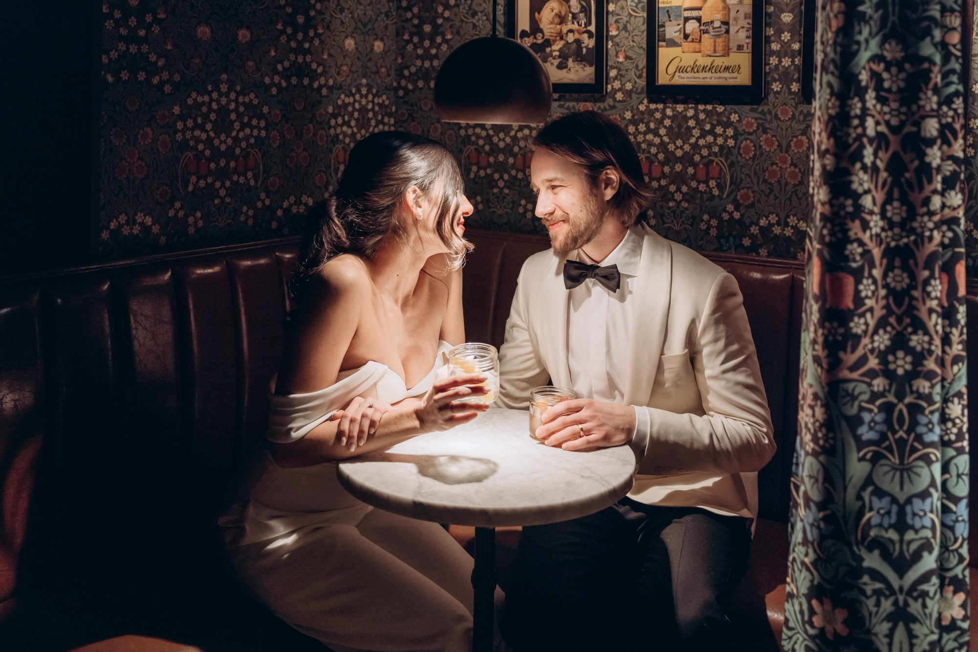 Happy bride and groom getting cocktails during their winter elopement at a cozy bar. Manhattan NY