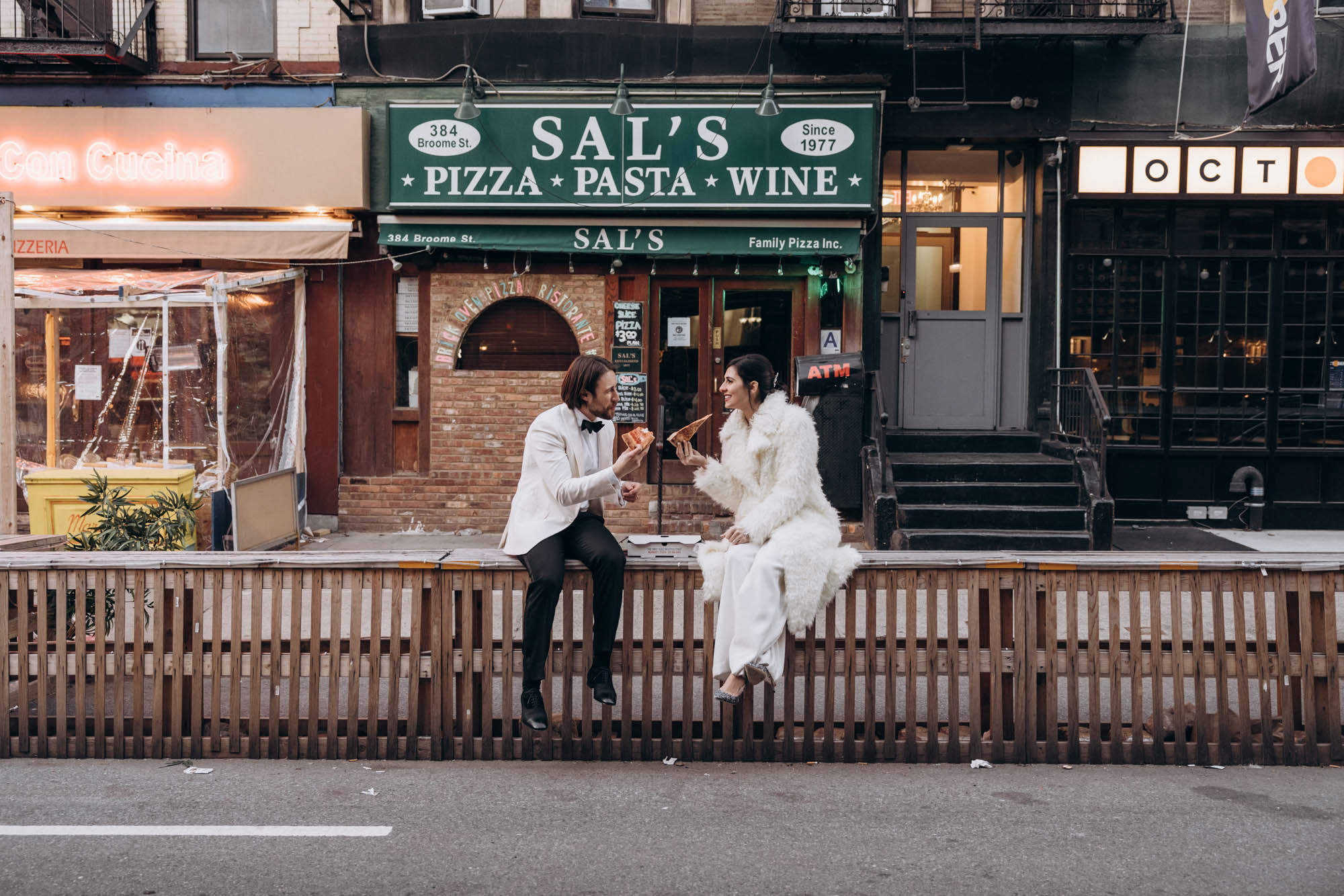 Happy bride and groom eating pizza in Little Italy, Manhattan NY
