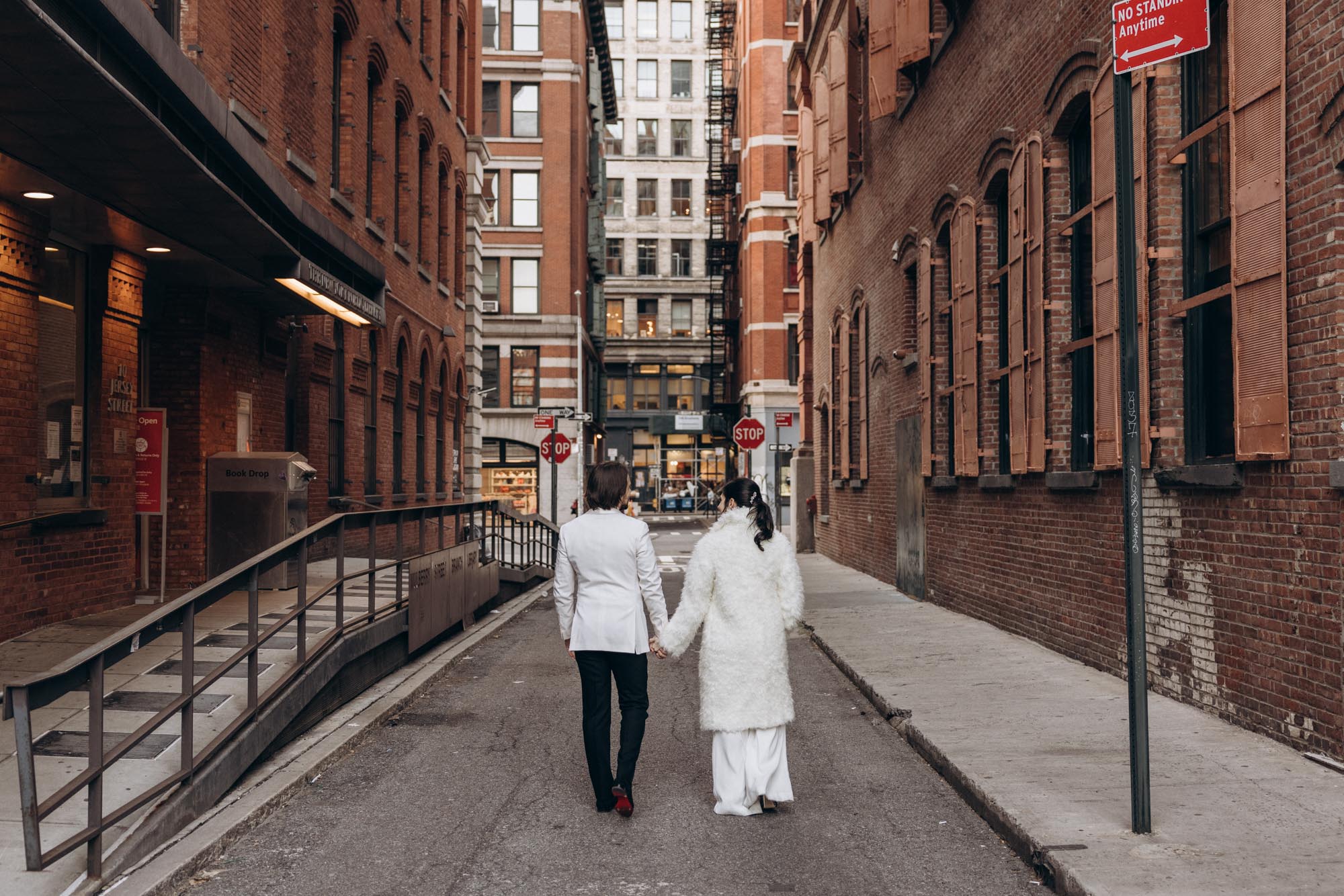 Stylish bride and groom walking on a cobble street in Soho. Manhattan NY