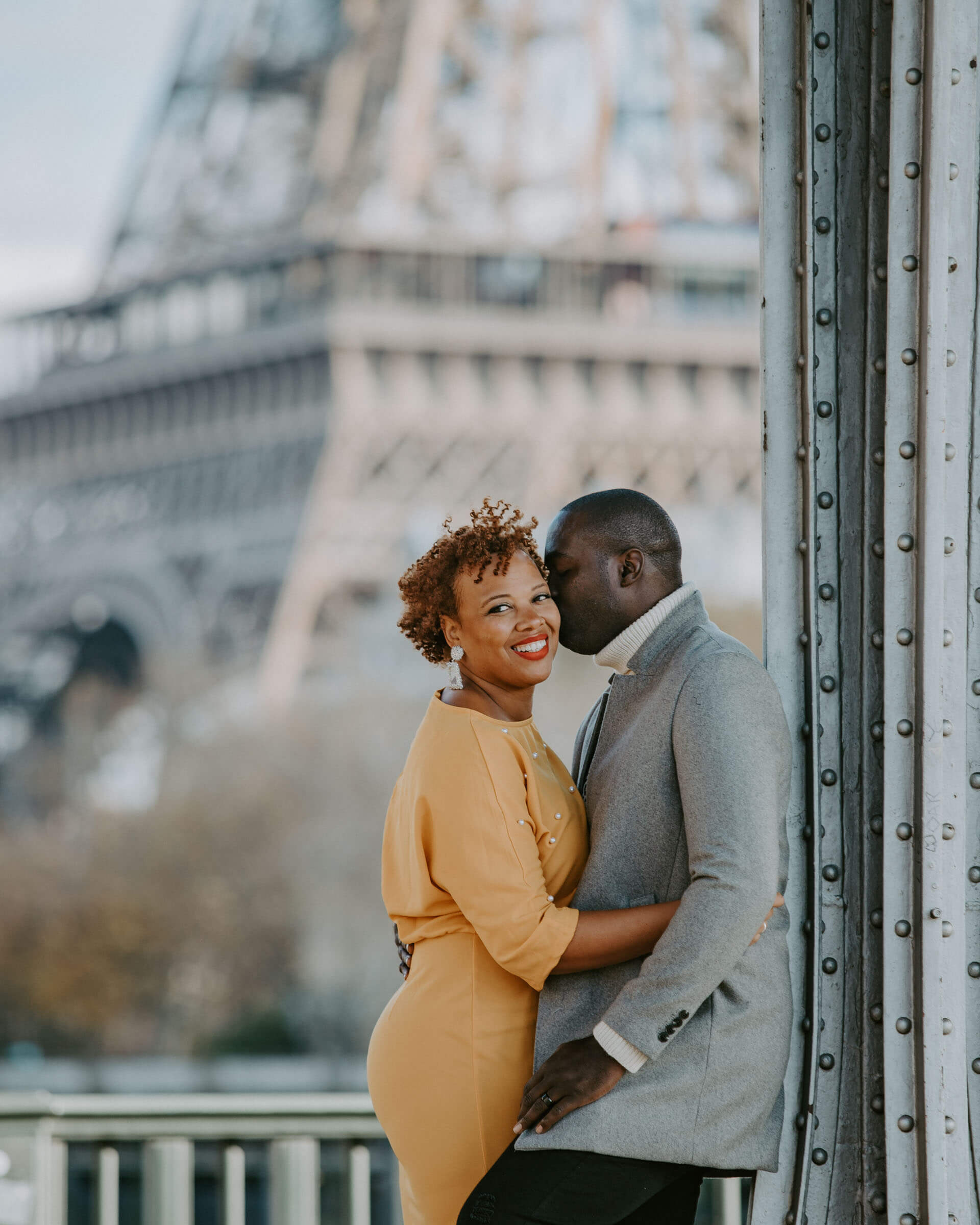 Elopement Paris-Beautiful couple with lady in a yellow dress hugging at Bir Hakeim bridge in Paris. Photo by PhilArty